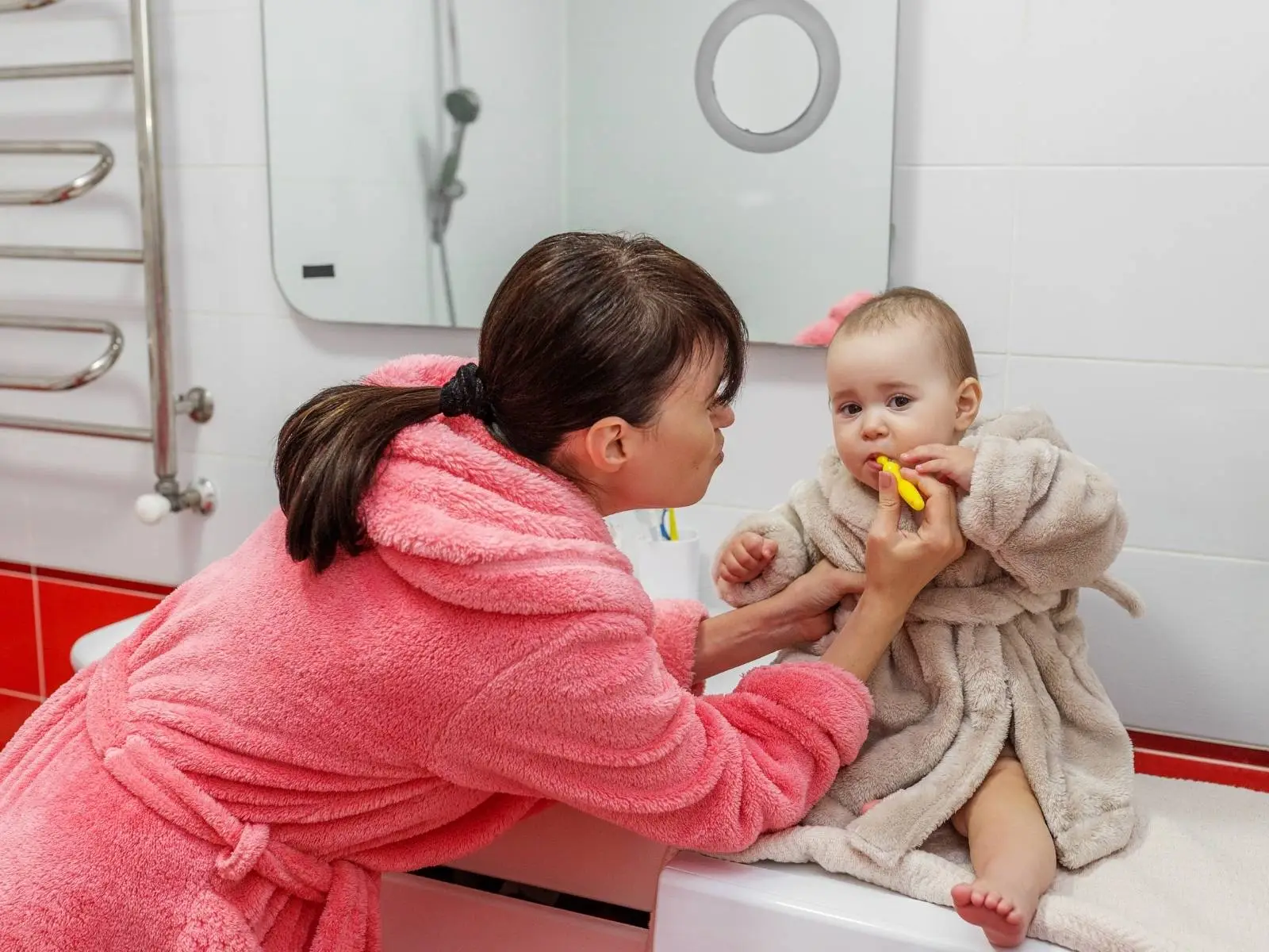 mom brushings babys teeth